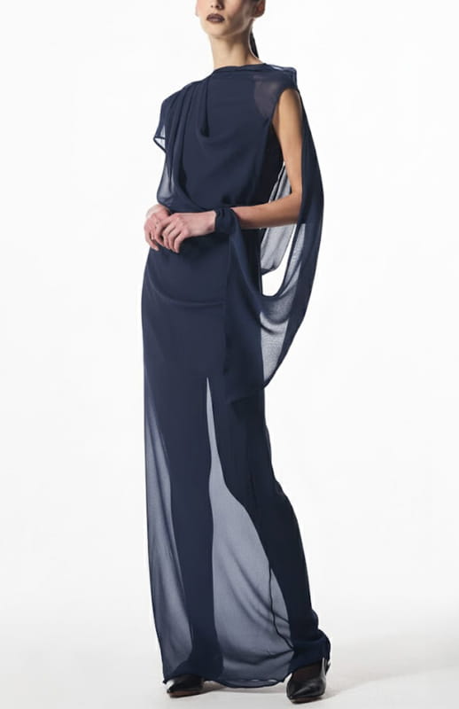 model is wearing long draped silk chiffon gown in navy