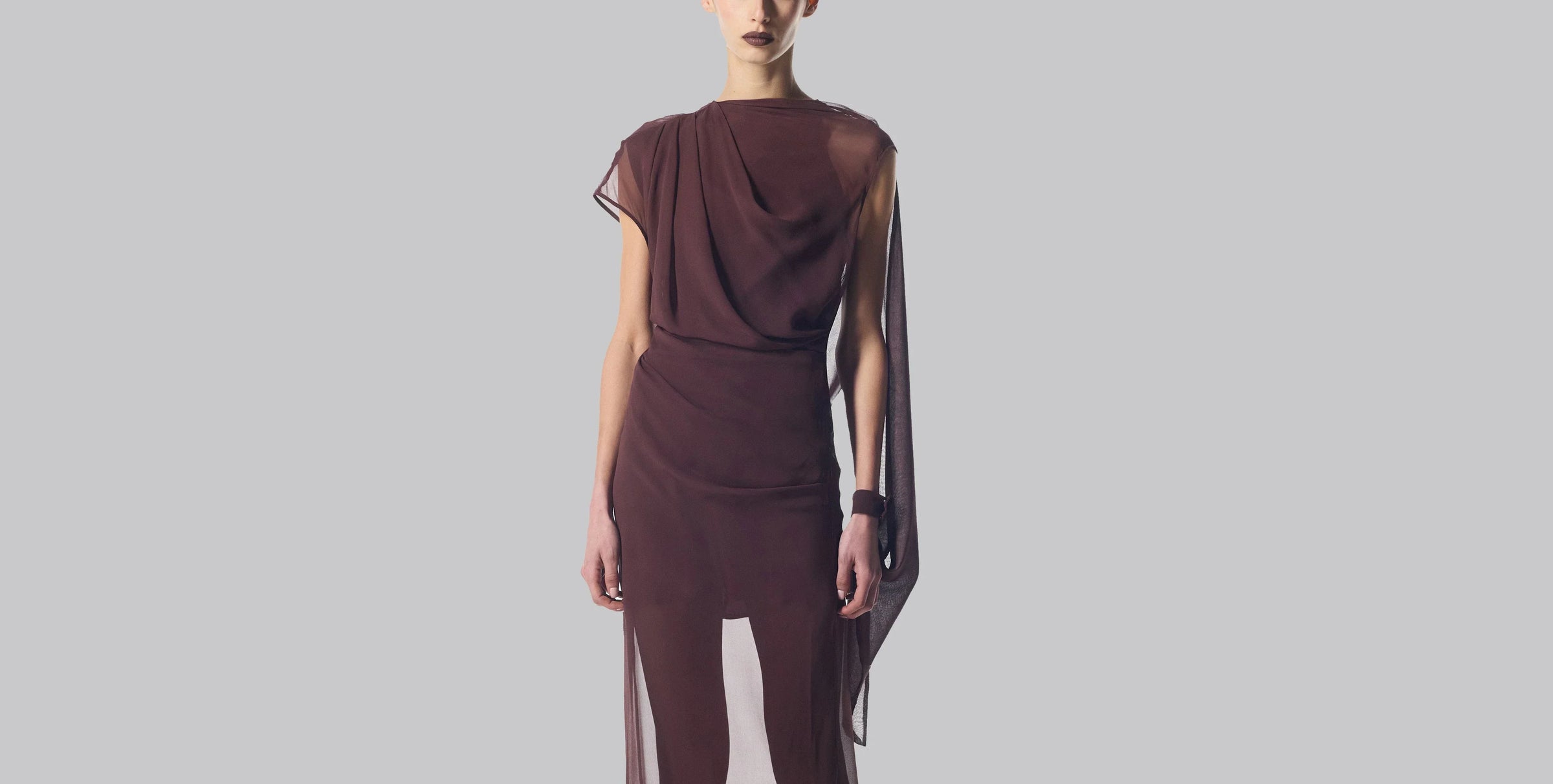 Elegant, off-white, one-shoulder gown with long black gloves.