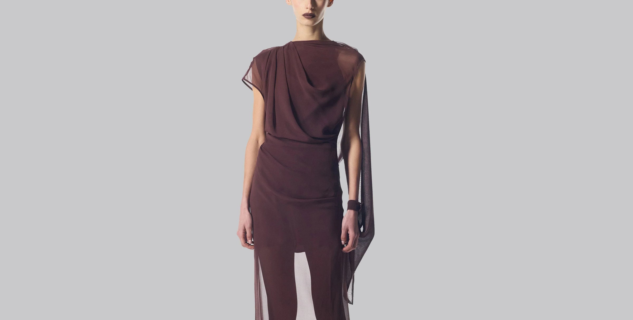 Elegant, off-white, one-shoulder gown with long black gloves.