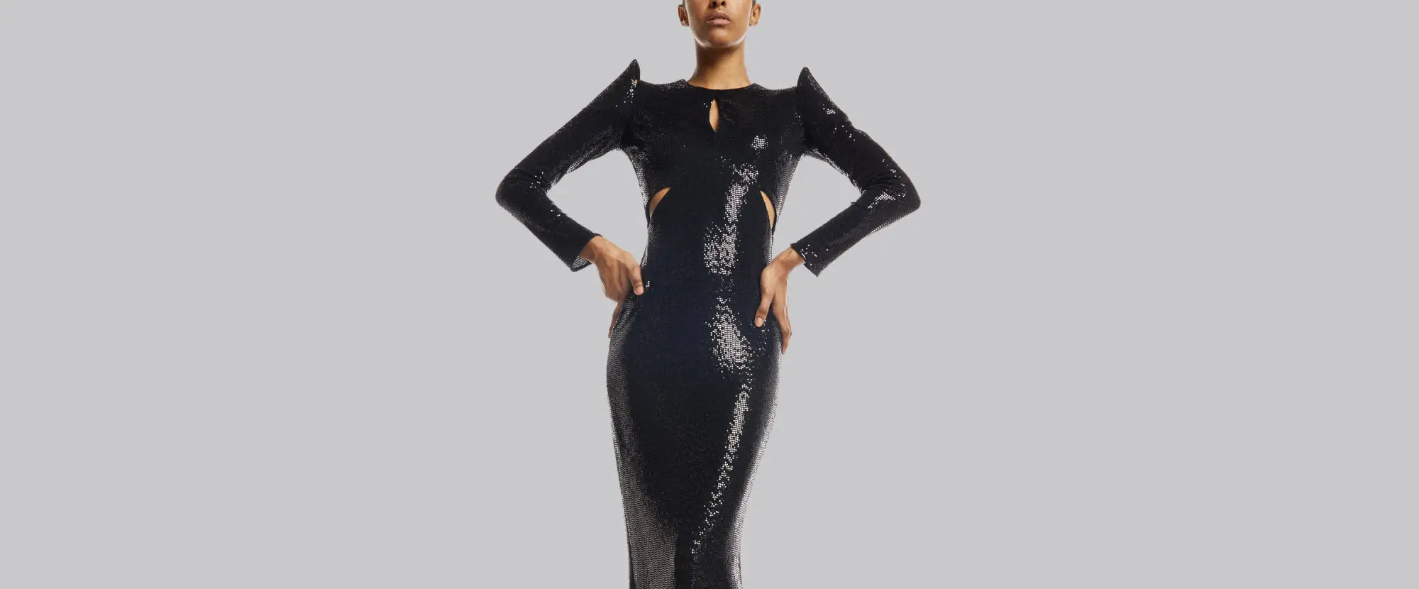 A black sequined gown with structured shoulders and cutouts.