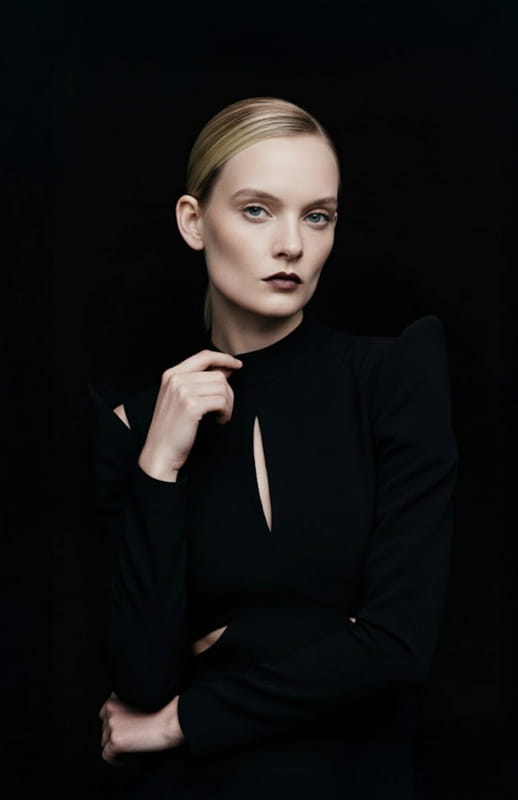 model is wearing sculptural black gown with sleeves