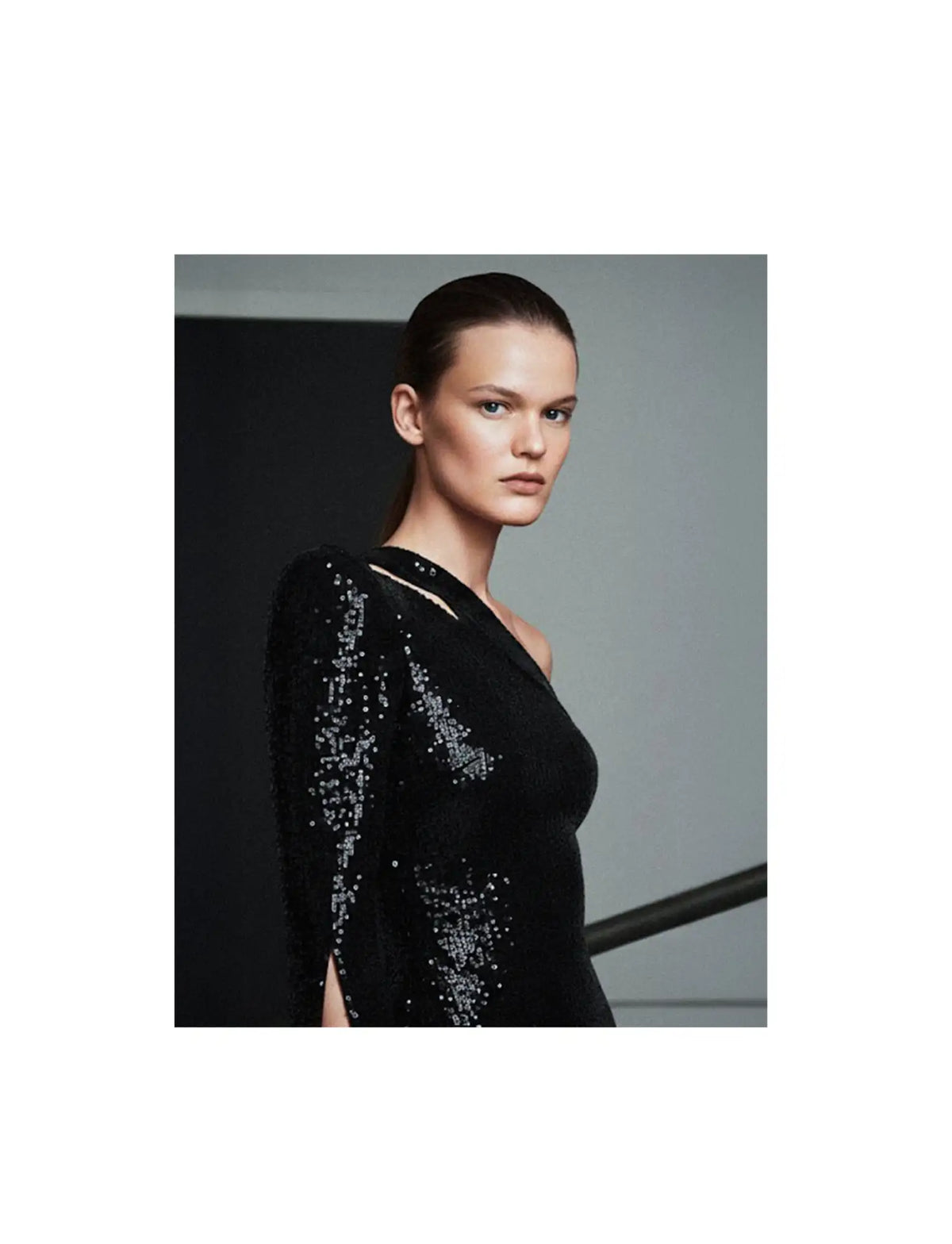 Black sequined dress with long sleeves and a deep neckline.