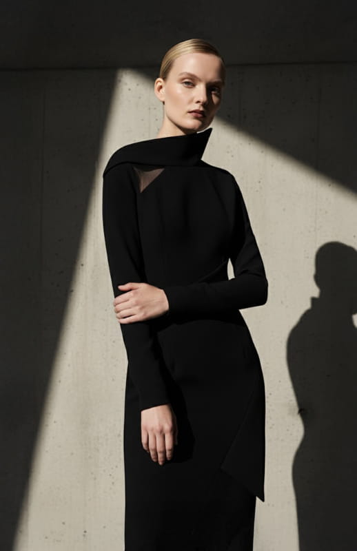 model is wearing architectural long black dress