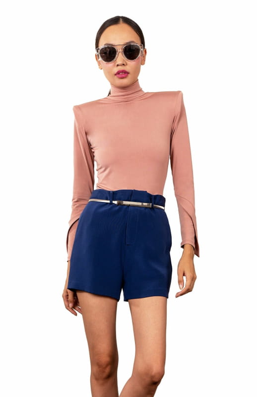 Nude, high shoulder pad bodysuit with a turtleneck and long draped sleeves.