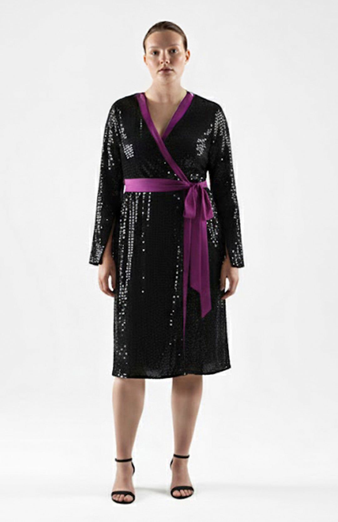 Plus size model wearing black sequin wrap dress with purple details