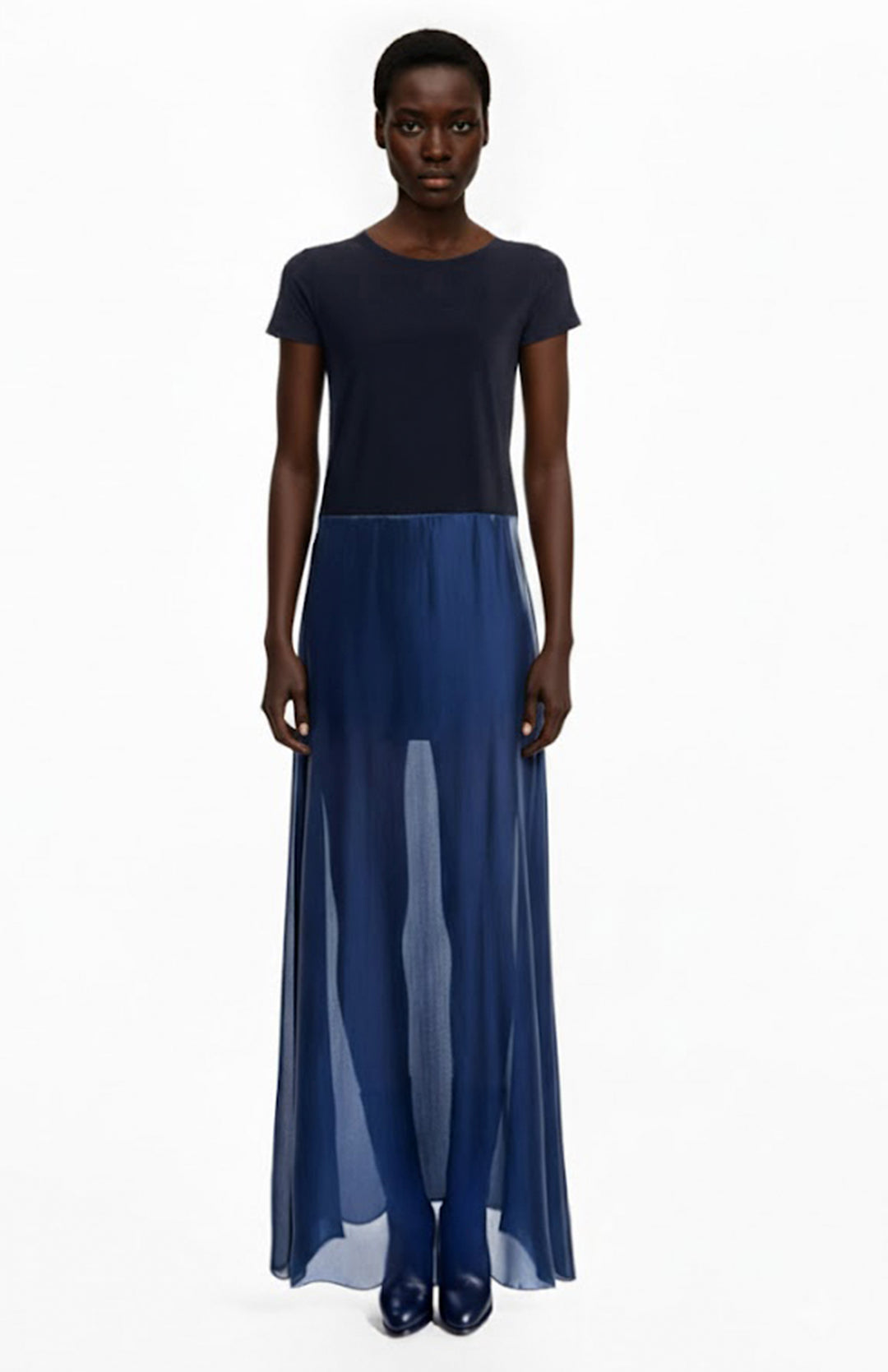 Model is wearing a long t shirt dress with a jersey top and sheer skirt