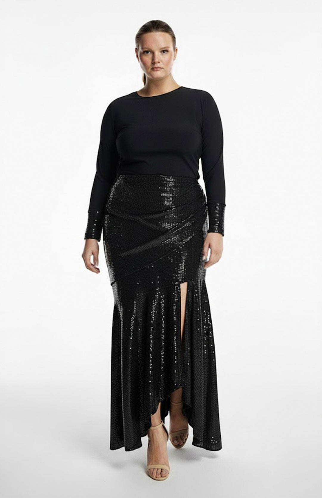 plus size model is wearing black turtleneck top and draped black sequin skirt