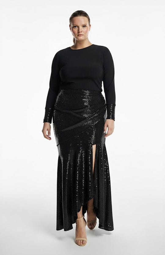 plus size model is wearing black turtleneck top and draped black sequin skirt