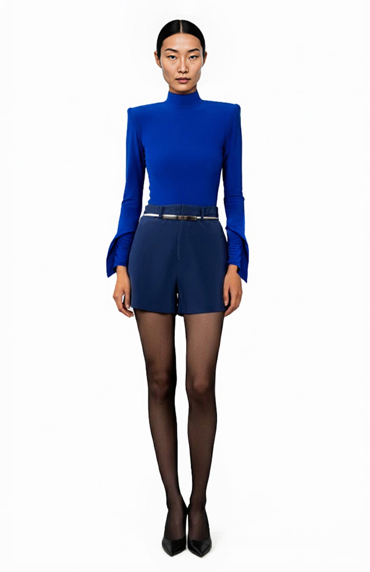 model wearing a blue bodysuit with high shoulder pads and navy shorts