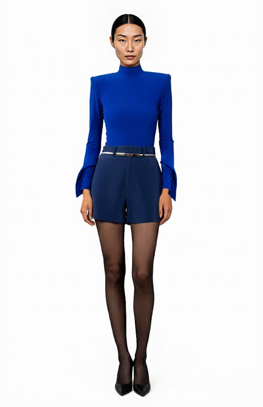 model wearing a blue bodysuit with high shoulder pads and navy shorts