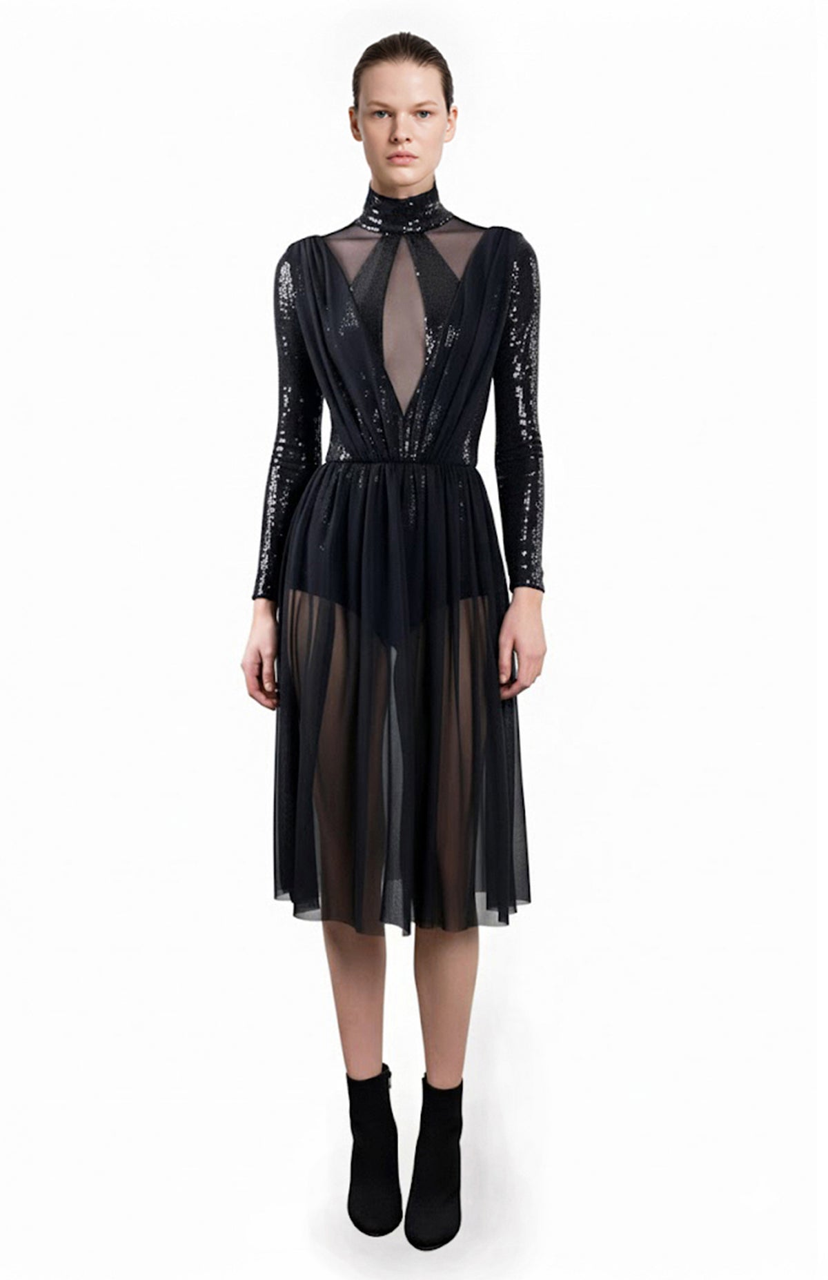 Model wearing black sequin bodysuit dress with sheer skirt and panels