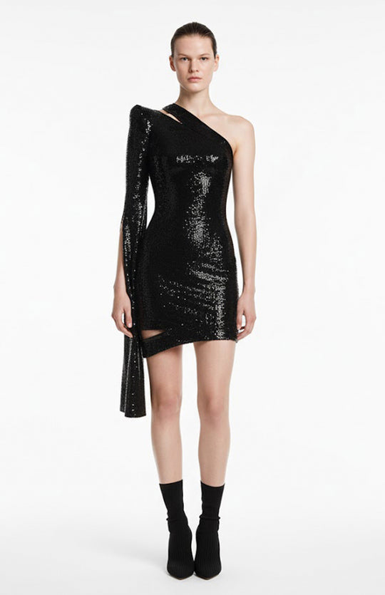 Model is wearing one sleeve mini black sequin dress with cutouts