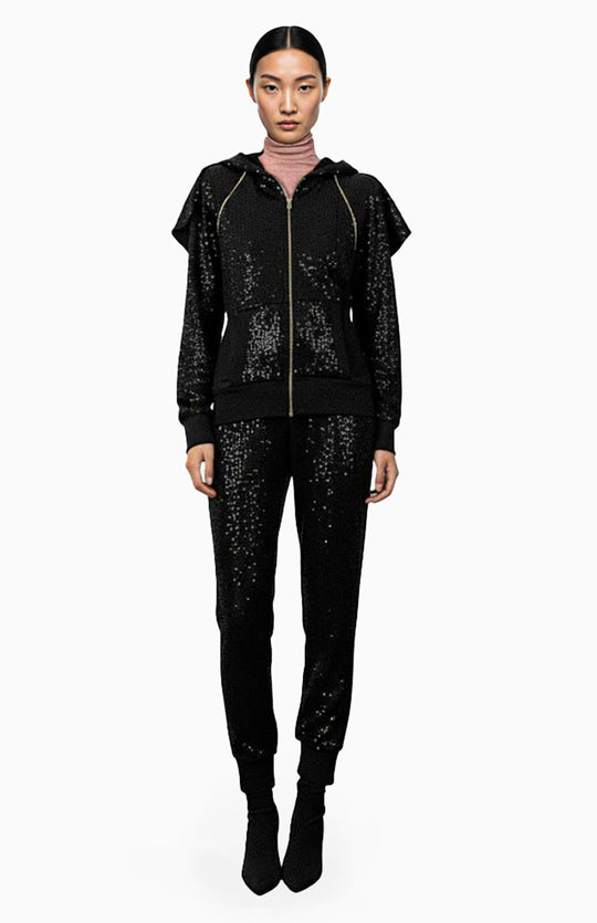 model is wearing oversized black sequin hoodie and black sequin pants