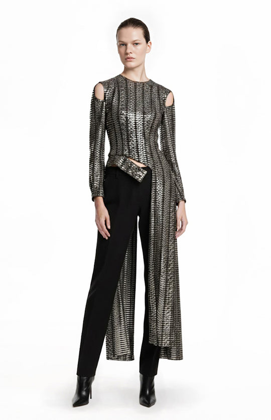 model is wearing metallic top with tails and black pants
