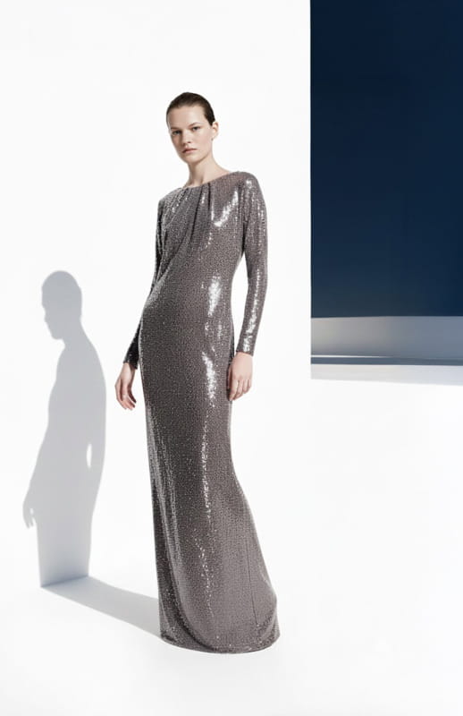 model is wearing a long silver sequin dress with long sleeves