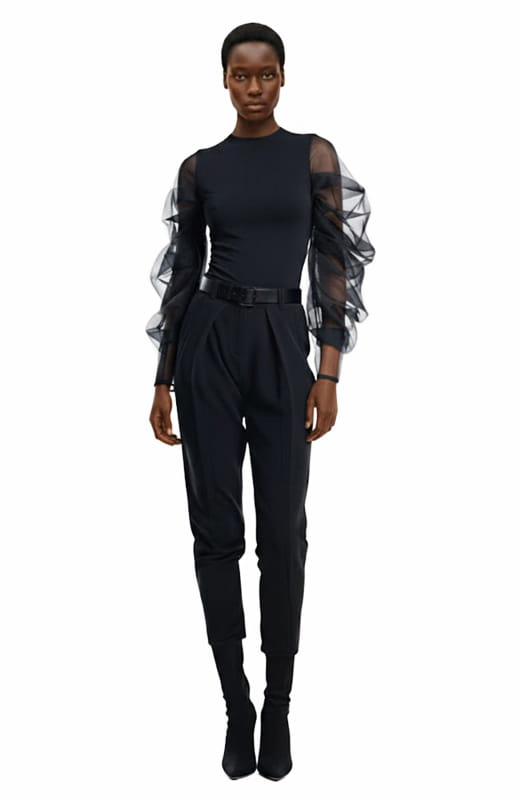 black model is wearing black couture top with sculptural sheer sleeves and black pants