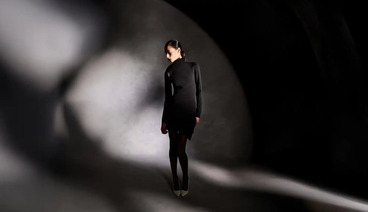 A woman in a black dress and tights.
