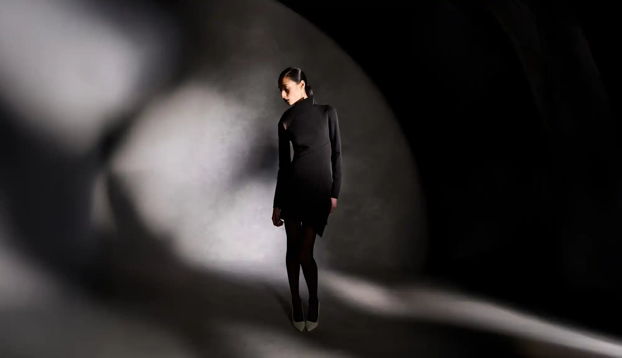 A woman in a black dress and tights.