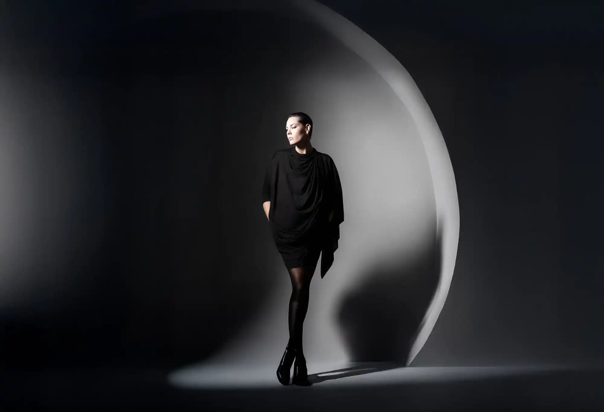 Woman in a stylish black dress and tights.