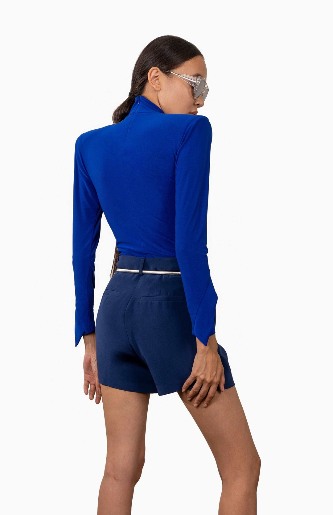 Chic, Royal blue, high shoulder pad bodysuit with a turtleneck and long draped sleeves.