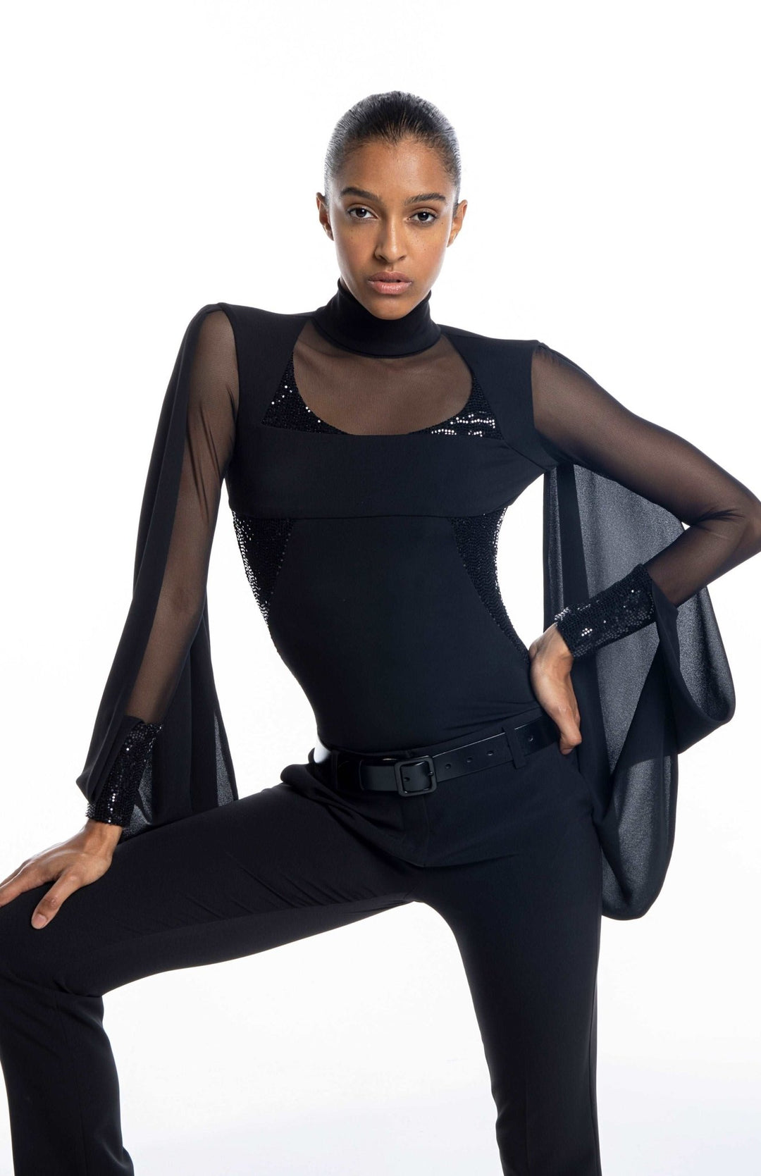 cool, black designer bodysuit with turtleneck, sheer neckline and sleeves, draped cape, and sequin contrast panels.