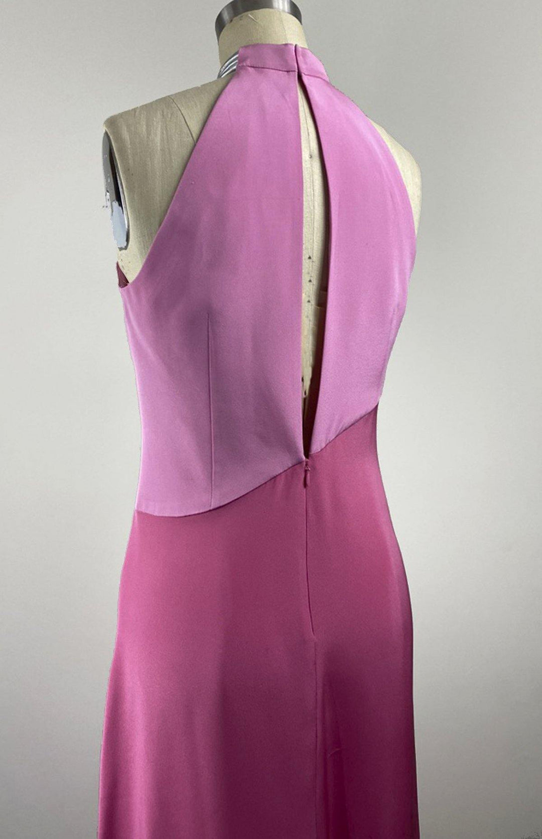 Pale pink and fuschia long, sleeveless, colorblock dress in double silk crepe with a futuristic silver neck trim detail. Back view