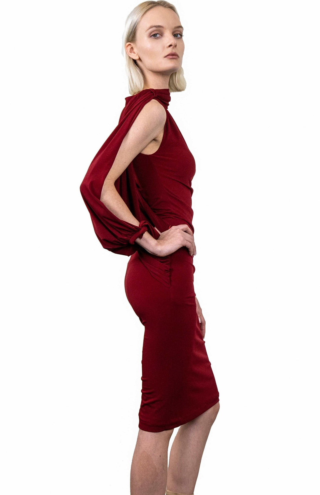 Dramatic, red, Grecian style, draped dress in jersey knit, with an asymmetrical oversized sleeve.