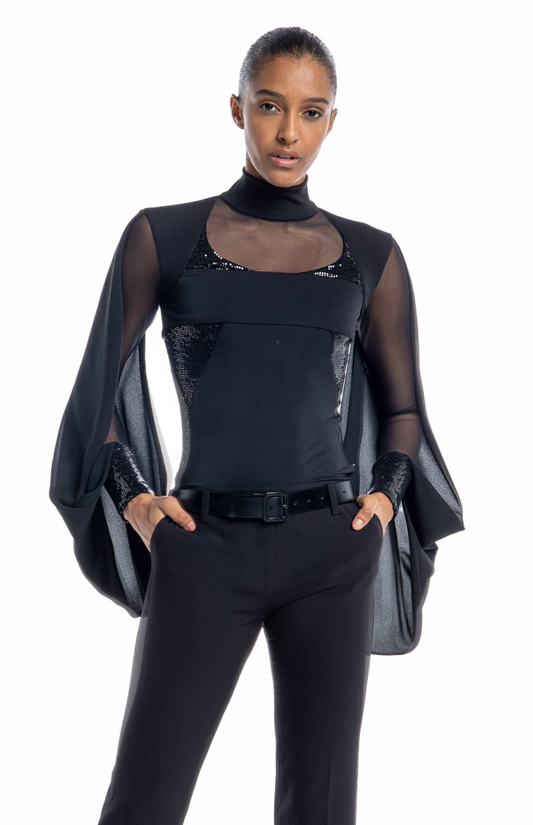 Edgy,  black designer bodysuit with turtleneck, sheer neckline and sleeves, draped cape, and sequin contrast panels.
