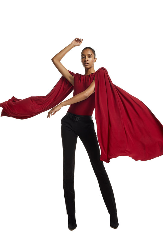 Glam,  draped bodysuit with shoulder pads and oversized cape sleeves