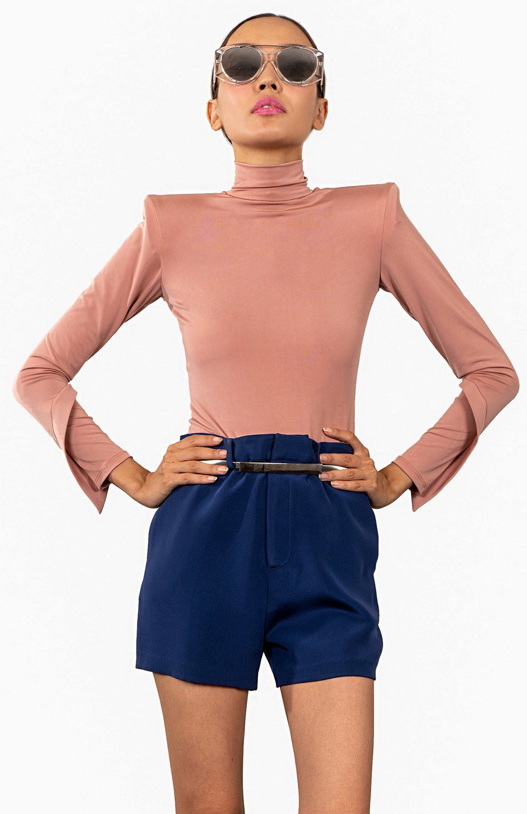 Chic, Nude, high shoulder pad bodysuit with a turtleneck and long draped sleeves.